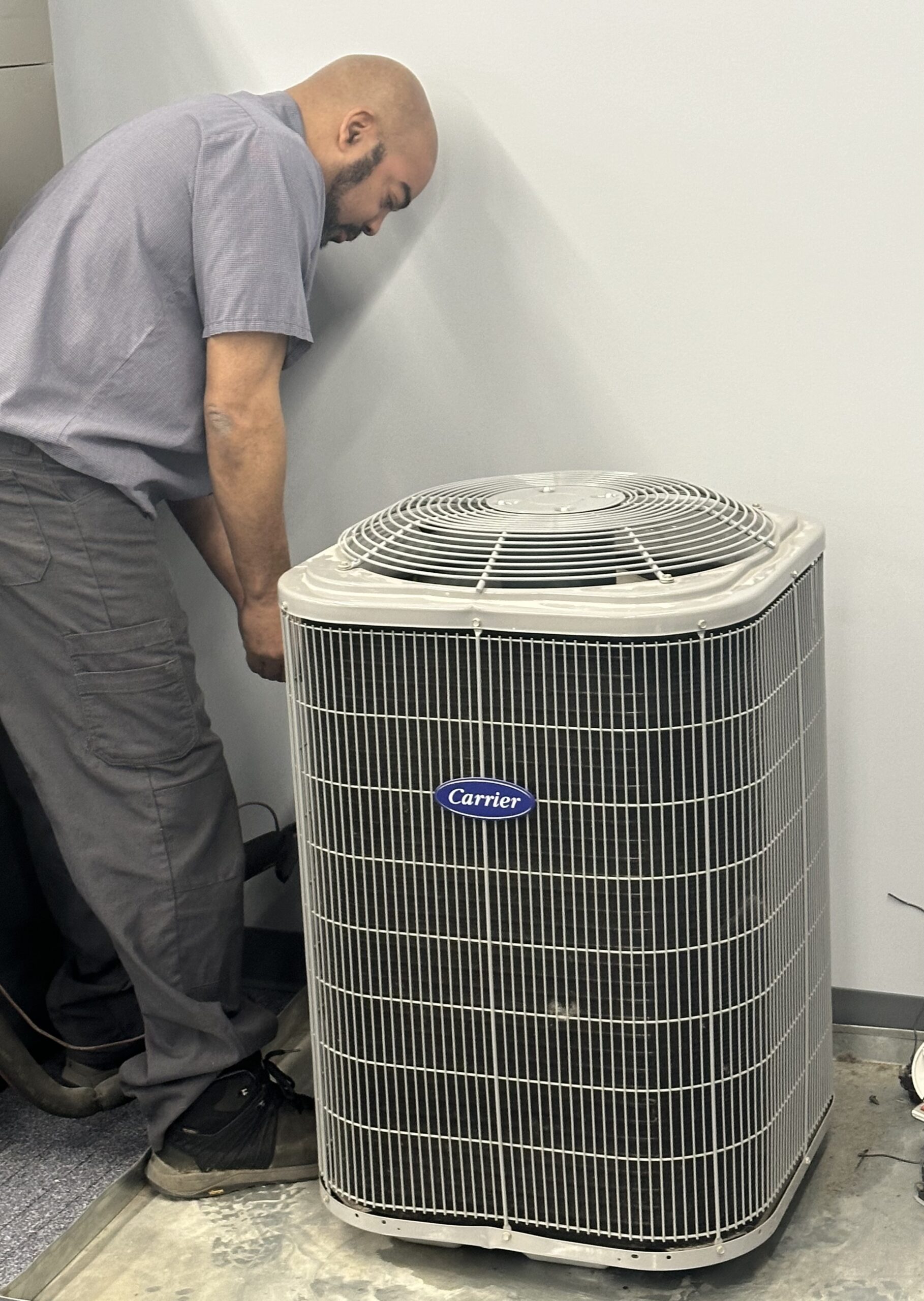 Masters Heating & Cooling technician preparing for an AC repair service appointment by getting a new air filter off the shelf
