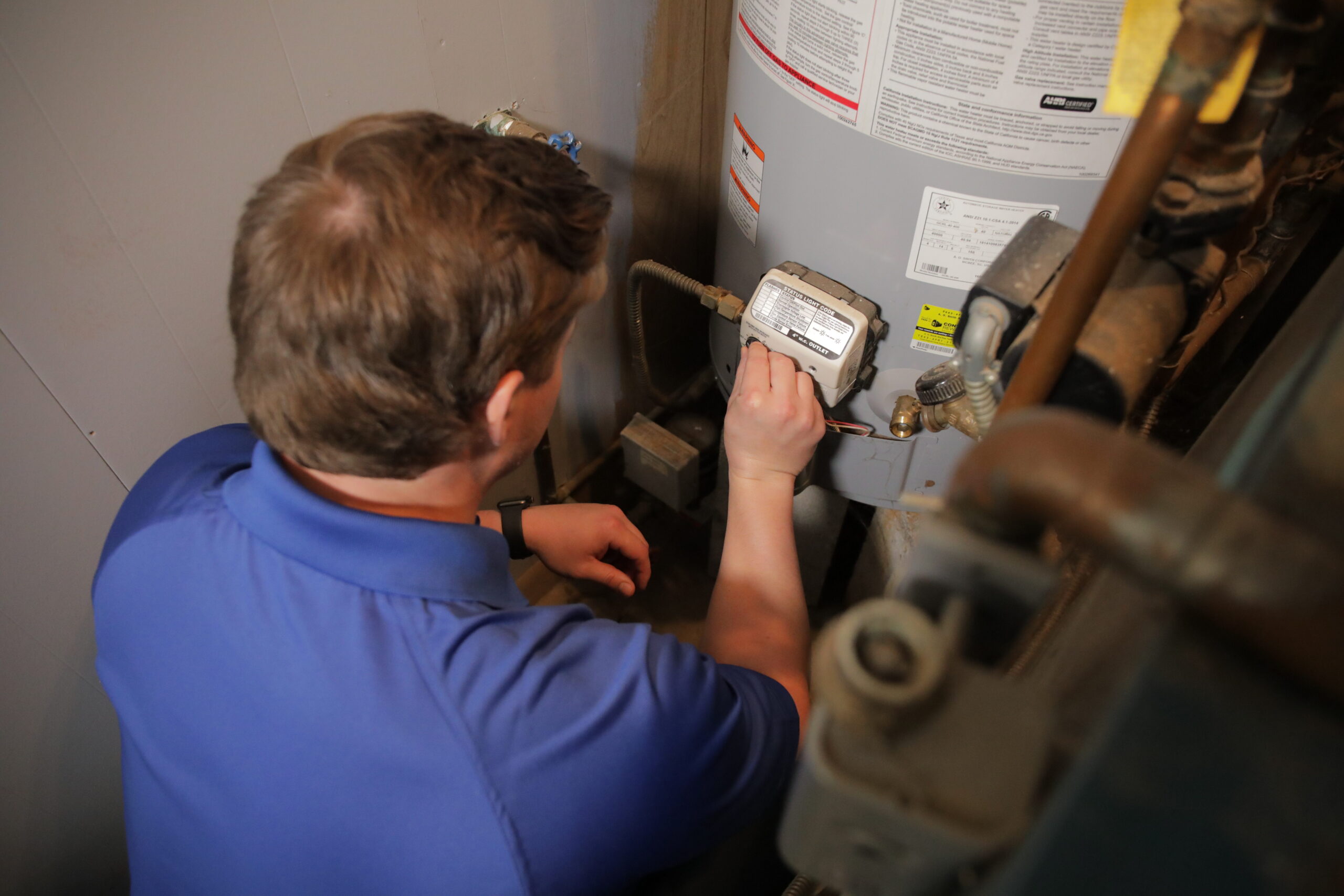 Plumber standing in front of newly installed residential water heater