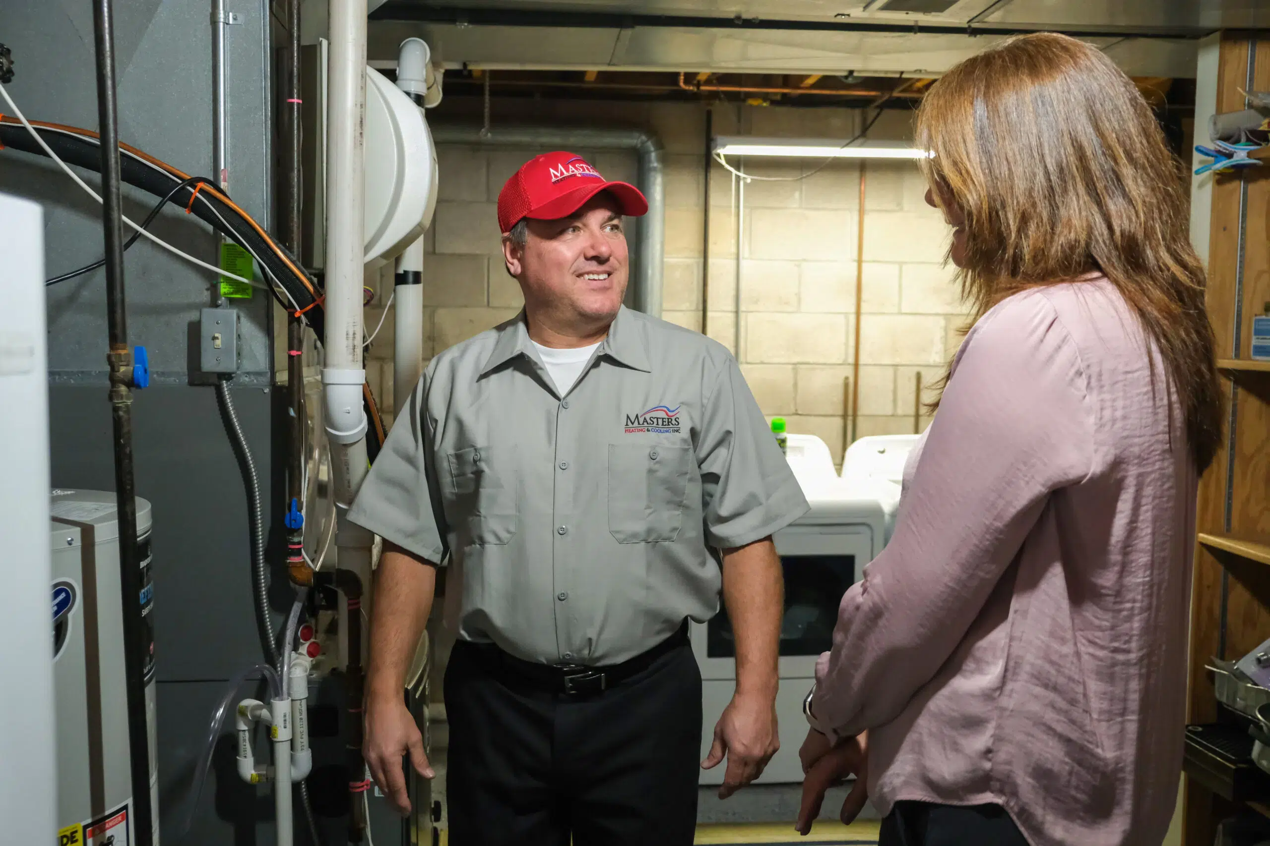 Masters Heating & Cooling technician speaking with a Decatur homeowner about their furnace
