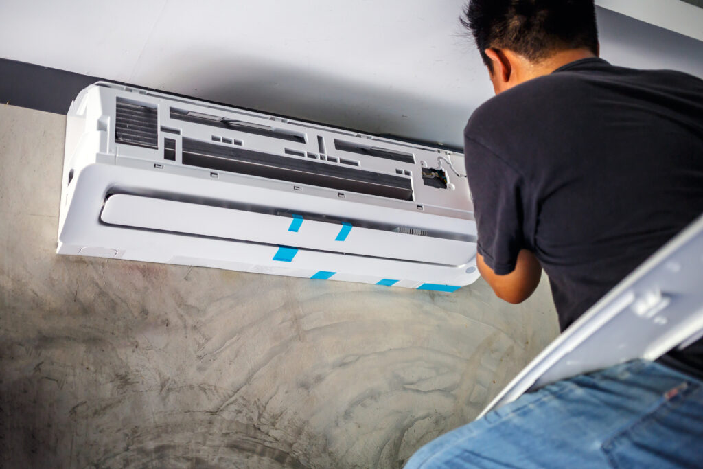 HVAC technician installing residential ductless heat pump mini-split head
